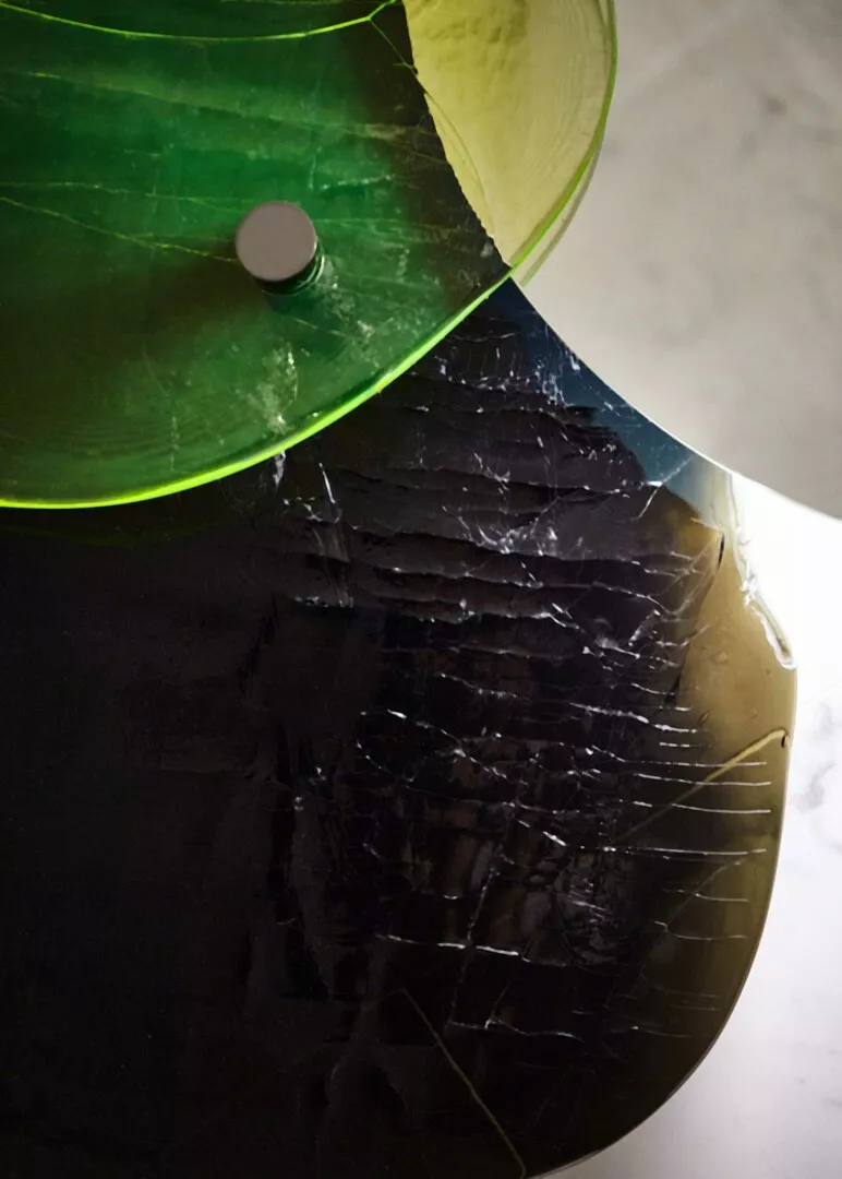 Artistic vinyl record with green overlay and cracks.